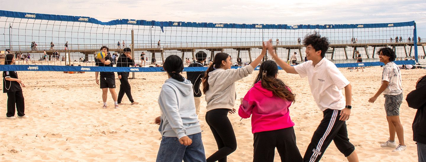 students playing Volleyball on beach
