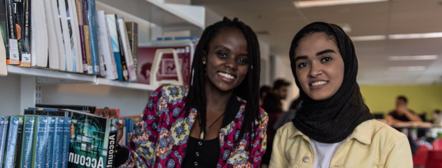 Females holding books in library