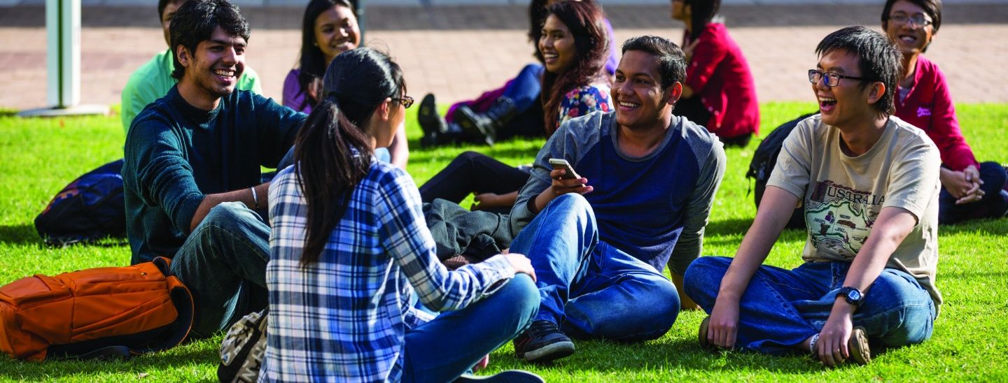 Group sittiing on grass talking