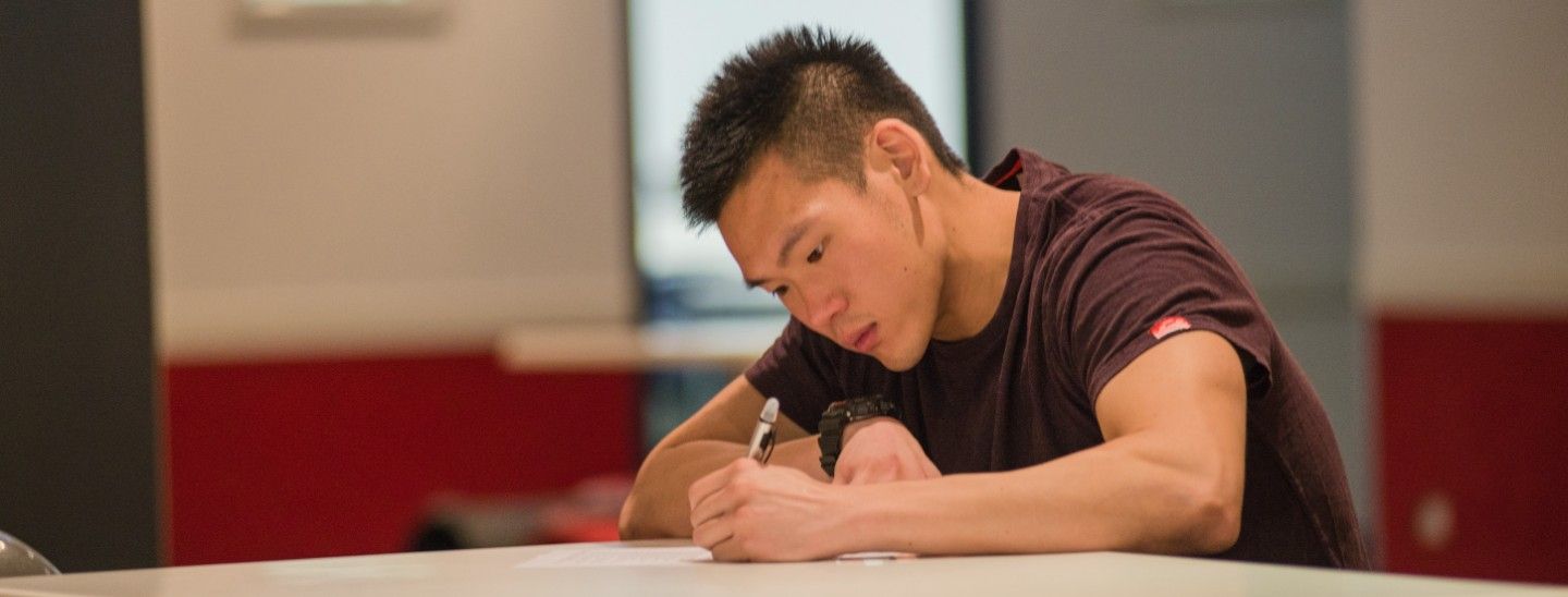 Male writing in class